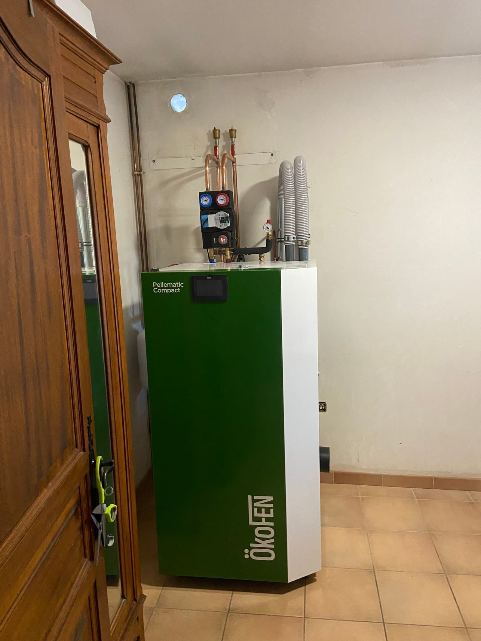 Chaudière à granulés de bois installée en local technique, avec départs en cuivre et circulateurs