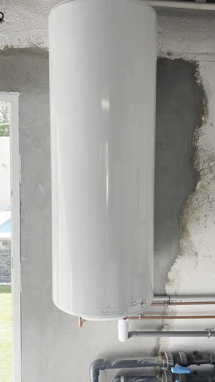 Ballon d'eau chaude électrique fixé au mur d'un local technique de piscine, raccordé en cuivre neuf, après la dépose d'une chaudière gaz